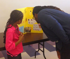 Parent and child with science poster.